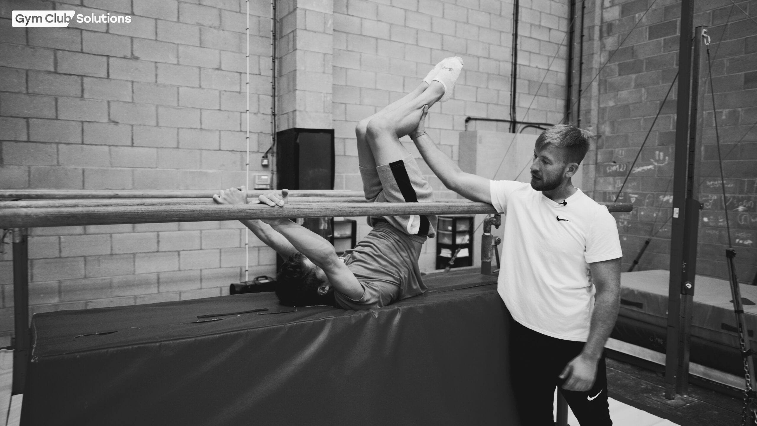 GCS coach working with a gymnast on beam
